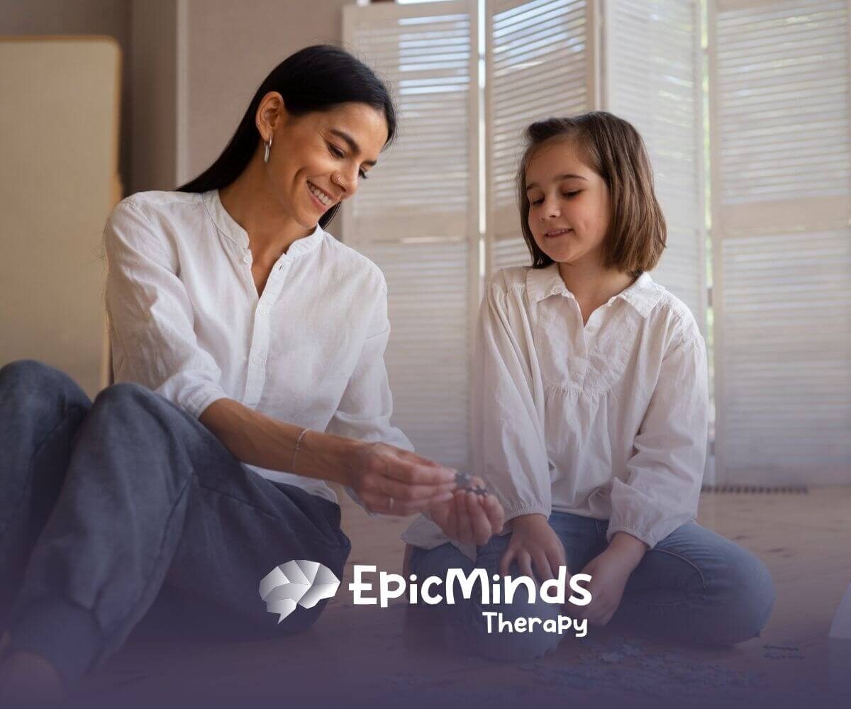 Smiling ABA therapist and autistic girl solving a puzzle together on the floor in ABA therapy.