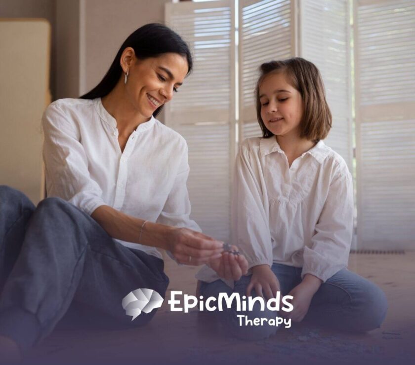 Smiling ABA therapist and autistic girl solving a puzzle together on the floor in ABA therapy.