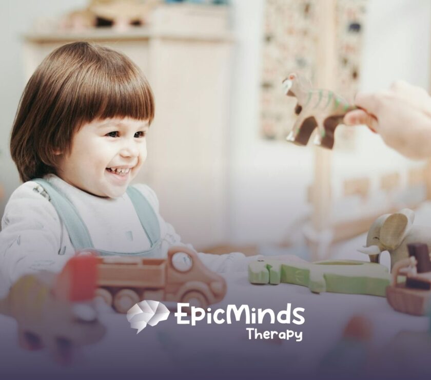 An autistic girl holding and inspecting a wooden toy helicopter at a table during ABA therapy in MD.