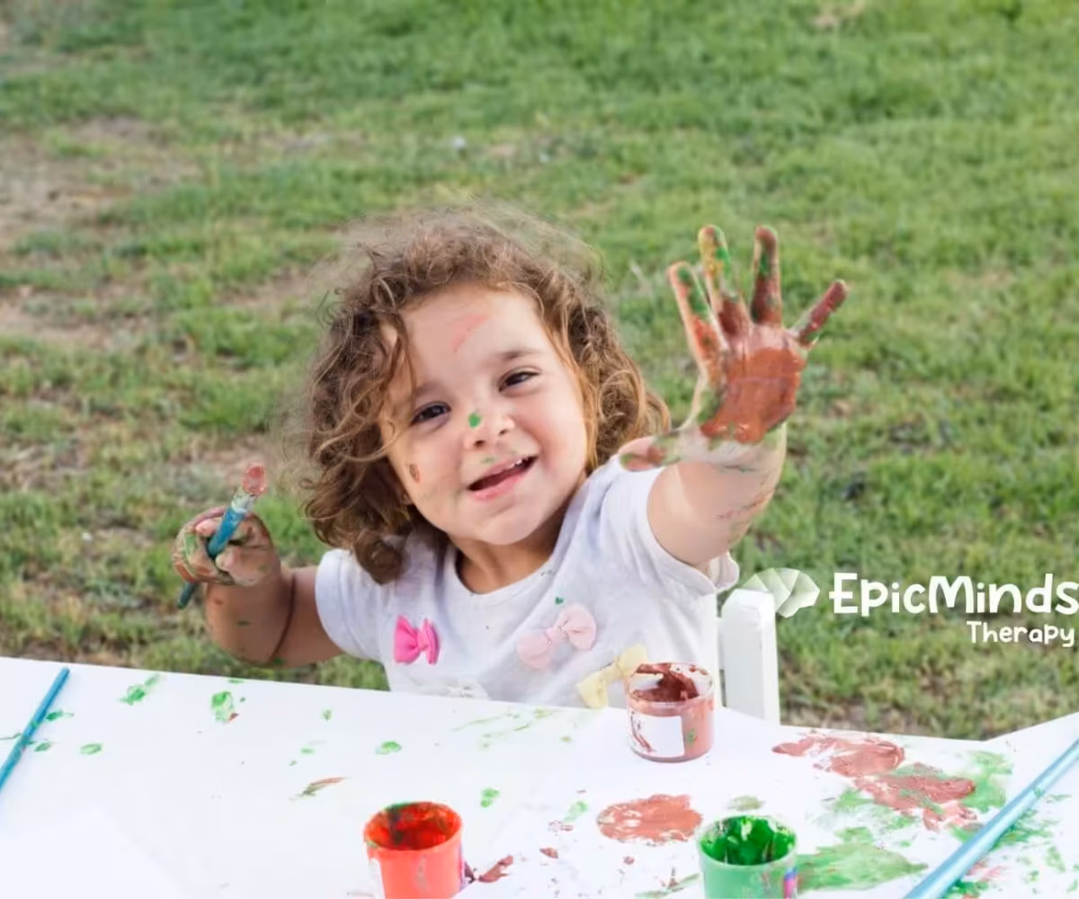 Child enjoying outdoor painting activity during ABA therapy.