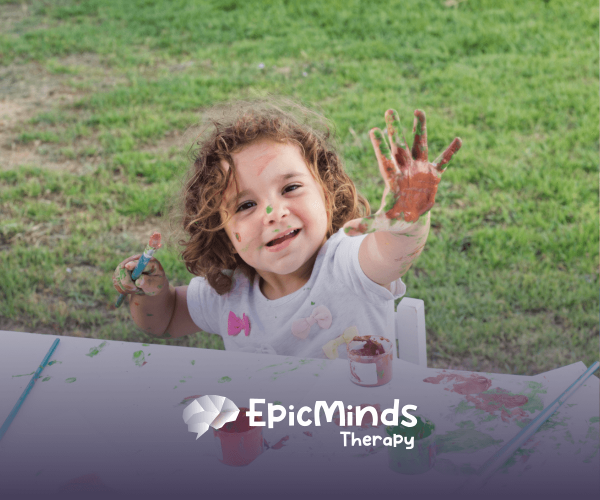 Child enjoying outdoor painting activity during ABA therapy.