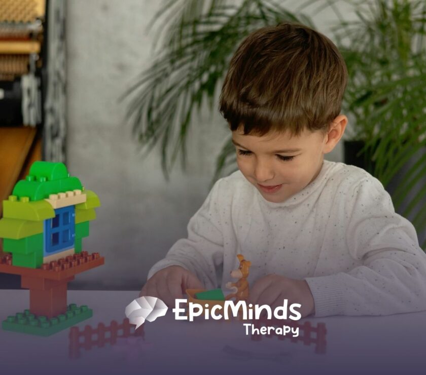 Young autistic boy playing with colorful building blocks and toy animals during ABA therapy in MD.