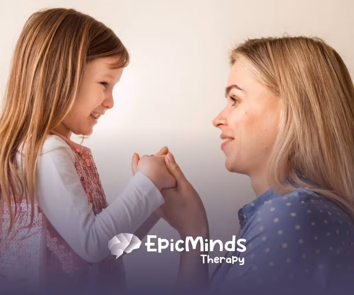 ABA therapist and autistic child holding hands and smiling before ABA therapy starts.