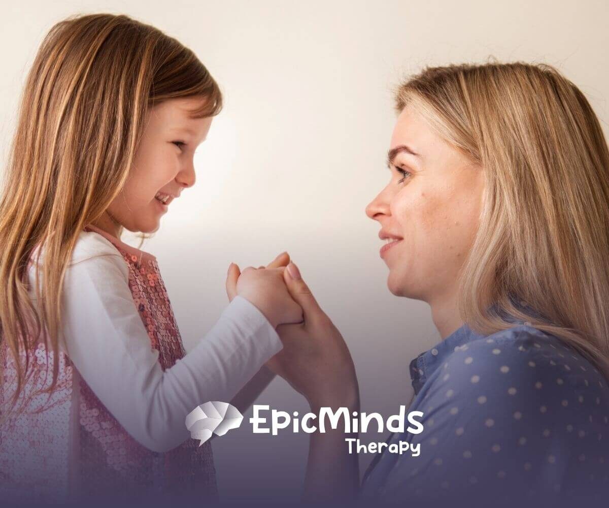 ABA therapist and autistic child holding hands and smiling before ABA therapy starts.