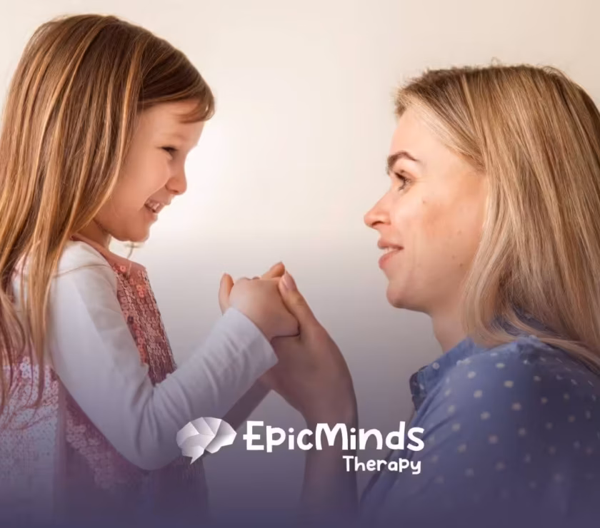 ABA therapist and autistic child holding hands and smiling before ABA therapy starts.