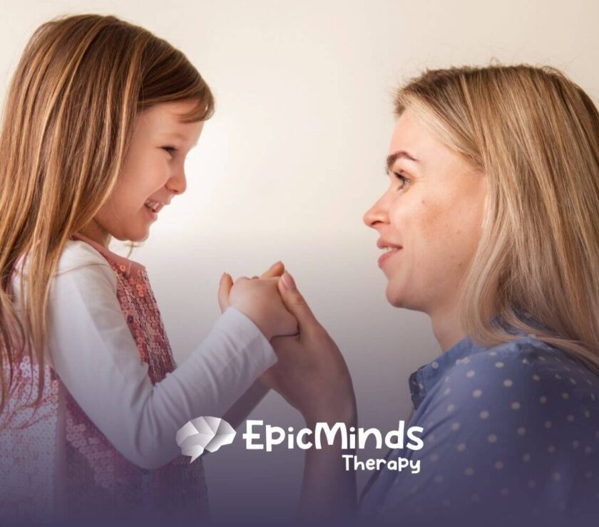 ABA therapist and autistic child holding hands and smiling before ABA therapy starts.