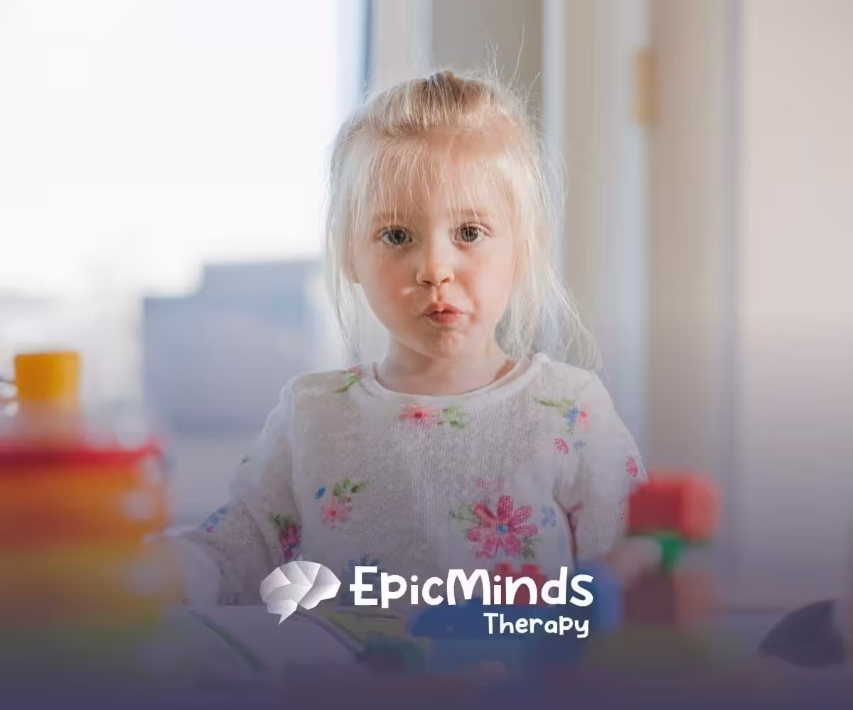 Autistic girl with blonde hair playing with colorful toys during ABA therapy session.