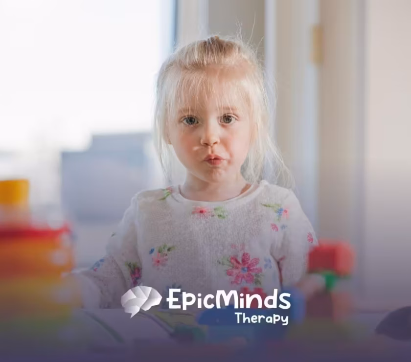 Autistic girl with blonde hair playing with colorful toys during ABA therapy session.