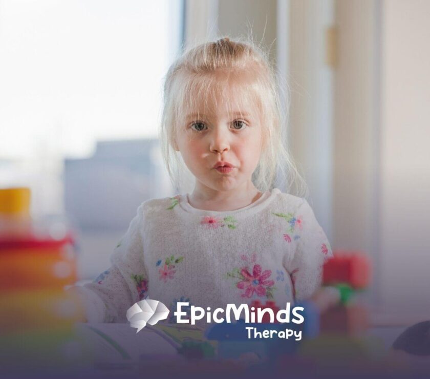 Autistic girl with blonde hair playing with colorful toys during ABA therapy session.