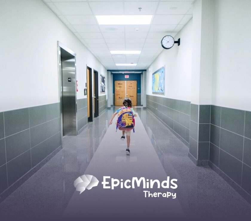 Autistic child walking down a school hallway with a backpack, heading to ca school-based ABA therapy in North Carolina.