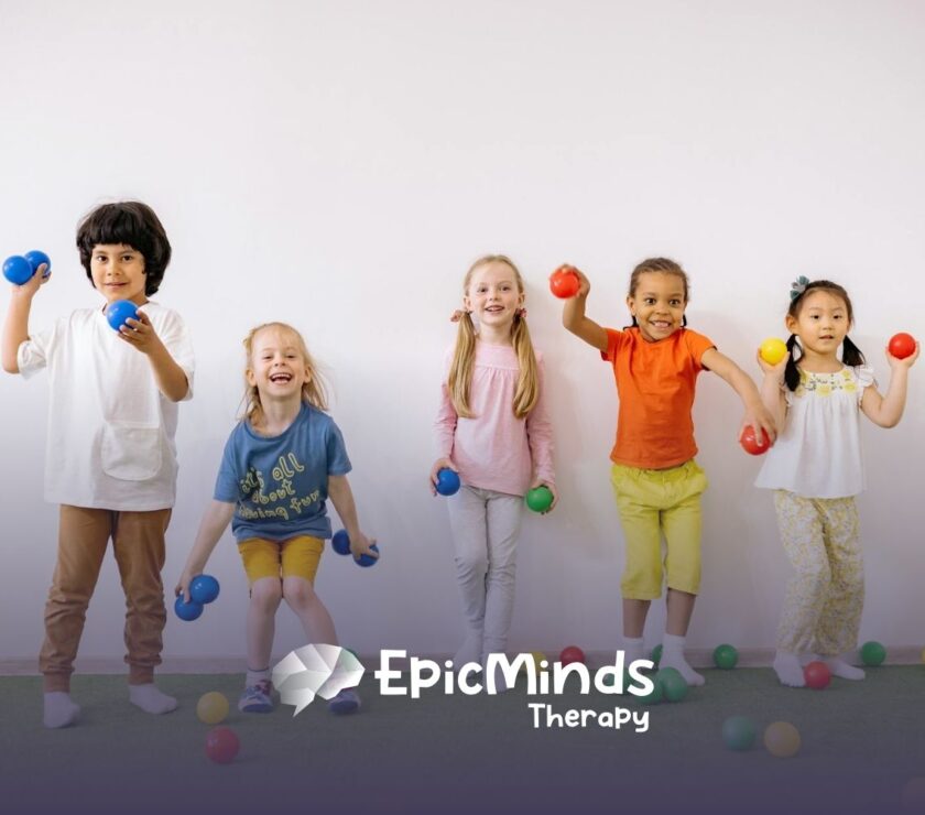 Group of smiling autistic children holding colorful balls in a playful indoor space during ABA therapy in NC.