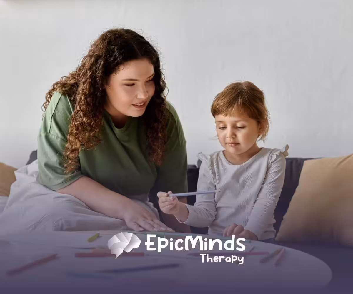 A girl with autism choosing a colored pencil while sitting at a table with an ABA therapist.