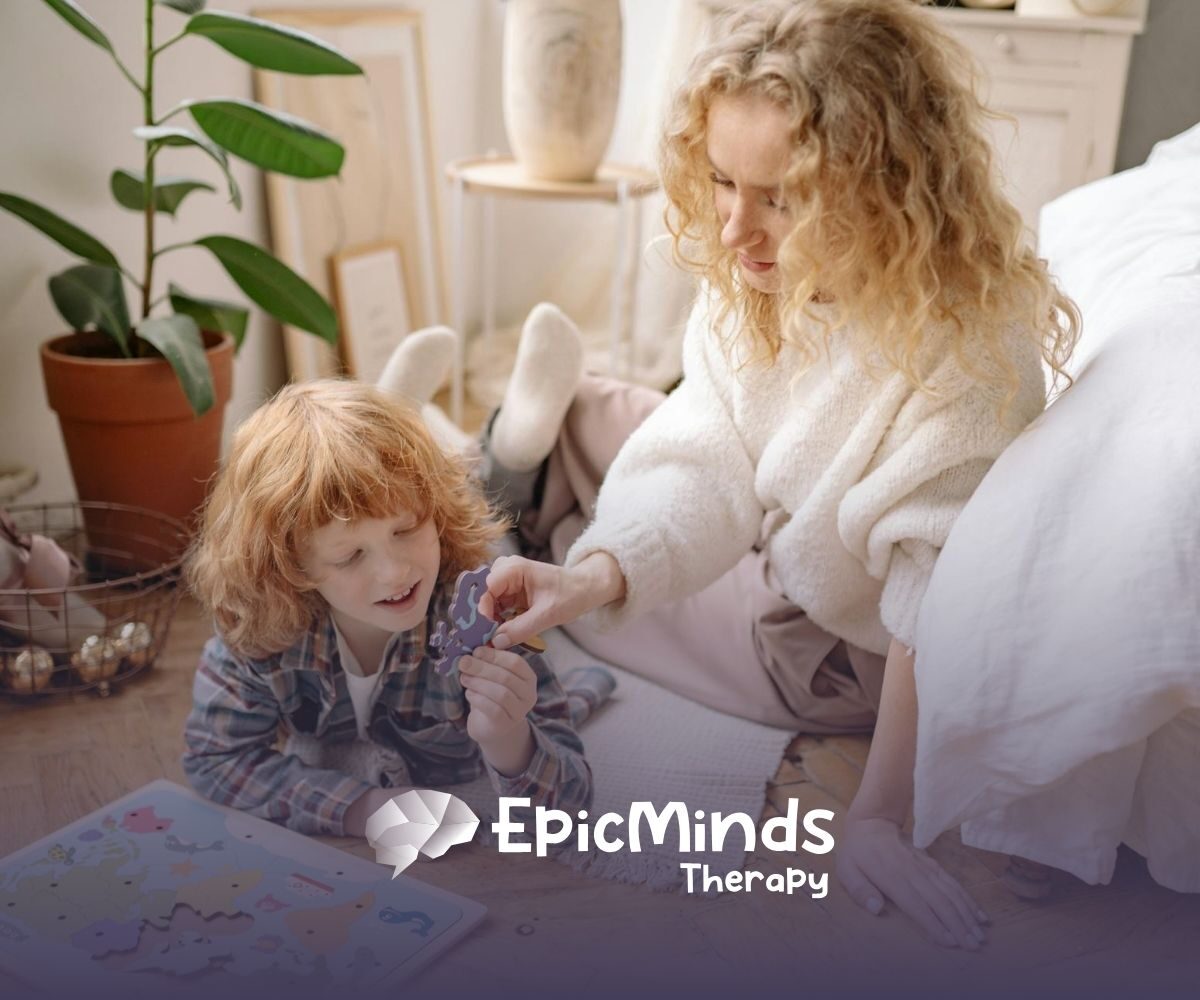 An ABA therapist and autistic child doing a world map puzzle on the floor together during in-home ABA therapy in NC.