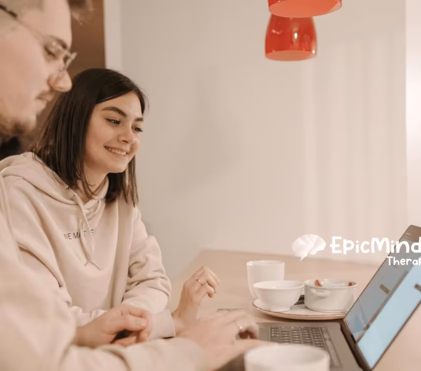 An RBT and RBT supervisor smiling while explaining the RBT supervision requirements at a laptop in North Carolina.