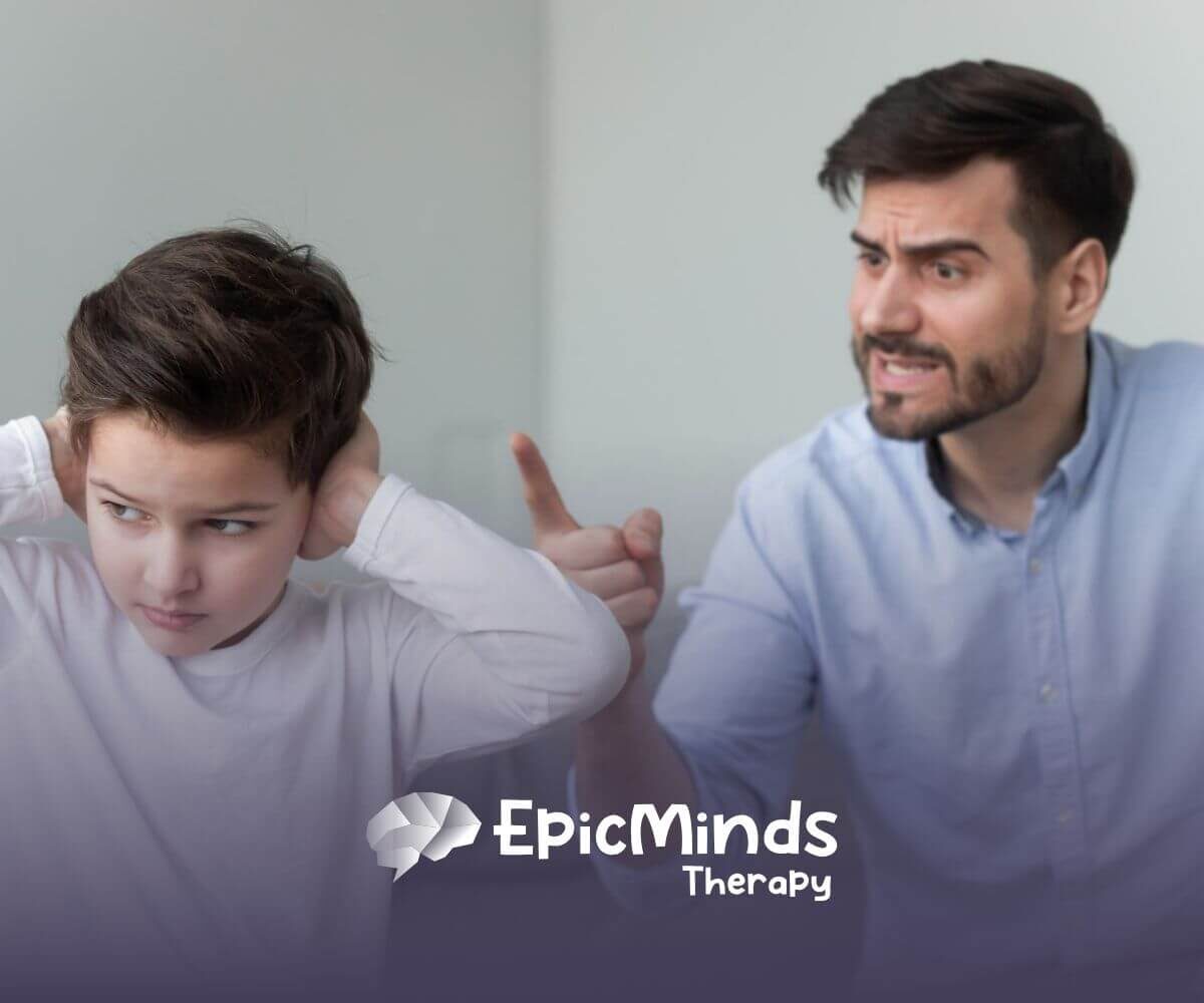 A boy with autism covering his ears while a man points and scolds him.