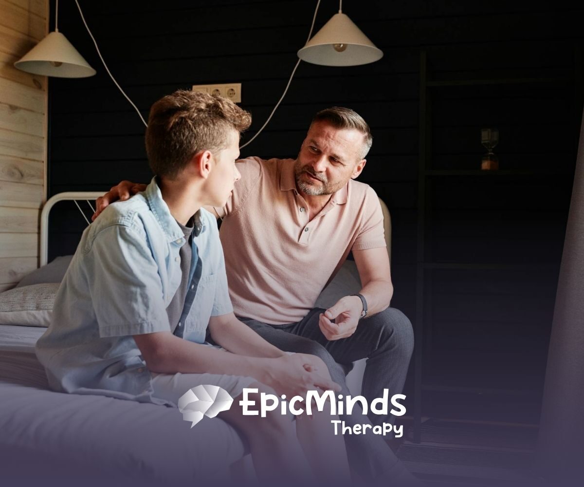 An ABA therapist and autistic child having a serious conversation while sitting on a bed in a cozy room in North Carolina.