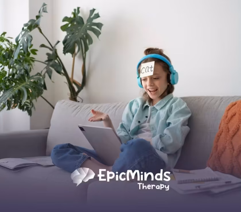 A girl with headphones and a "Cat" label on her forehead laughs while playing a guessing game on a tablet.