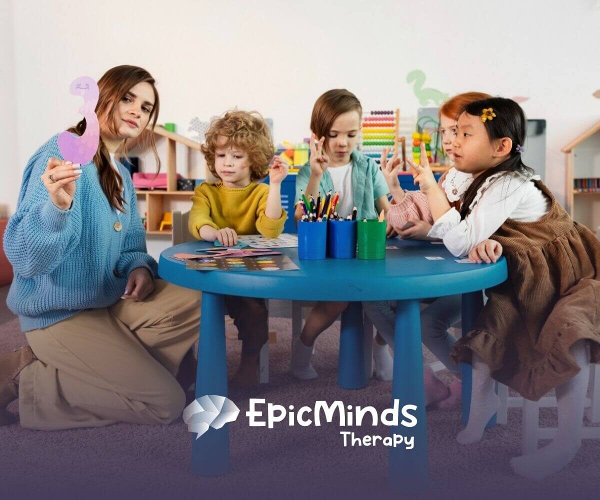 BCBA showing cutout number to children with autism at classroom table.