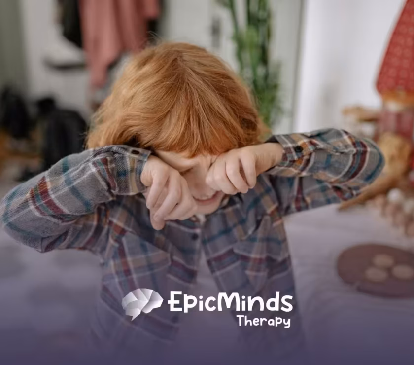 An autistic child with red hair getting upset and rubbing his eyes while standing in a kitchen in North Carolina.