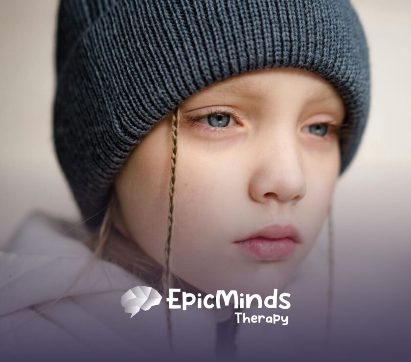 Close-up of an autistic child in a winter hat looking thoughtful outdoors in North Carolina.