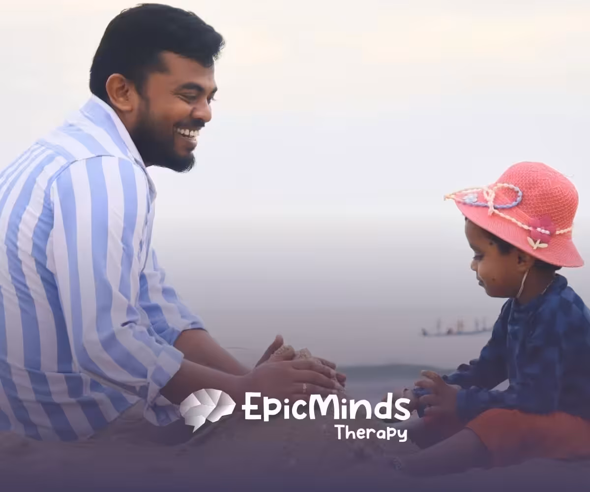 Dad and child play together by the water, shaping sand into a castle on the sunny beach in North Carolina
