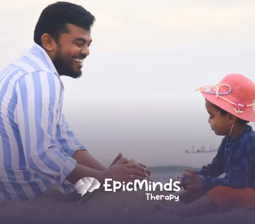 Dad and child play together by the water, shaping sand into a castle on the sunny beach in North Carolina