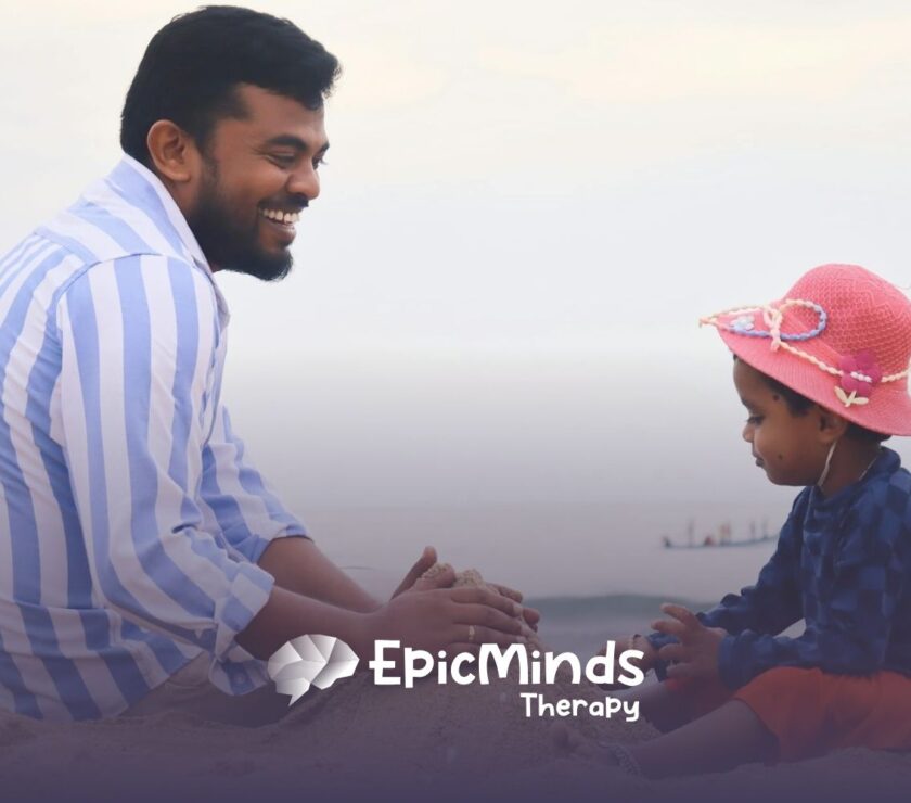 Dad and child play together by the water, shaping sand into a castle on the sunny beach in North Carolina