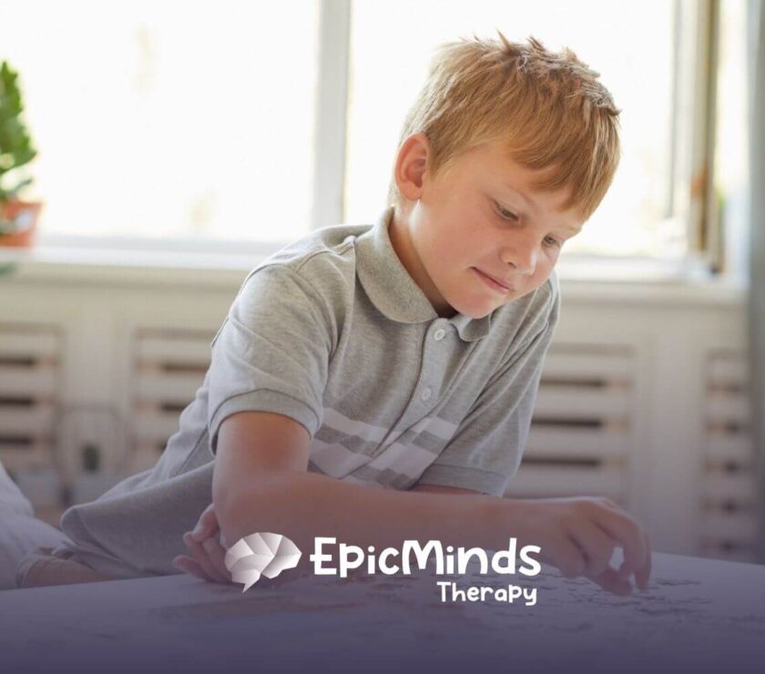 Boy with autism solving a puzzle at home during an educational activity.