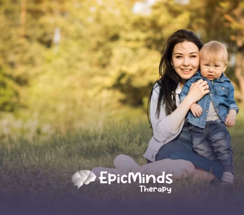 Mother sitting on grass with her young child enjoying outdoor time after ABA therapy session.