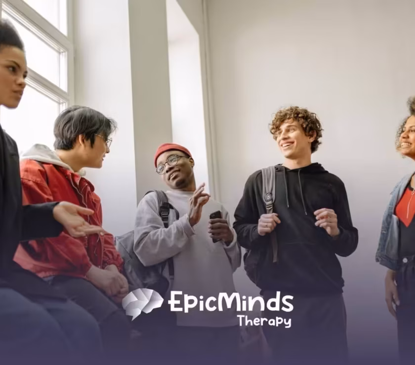 Group of autistic young adults chatting and laughing together indoors after their ABA therapy in North Carolina