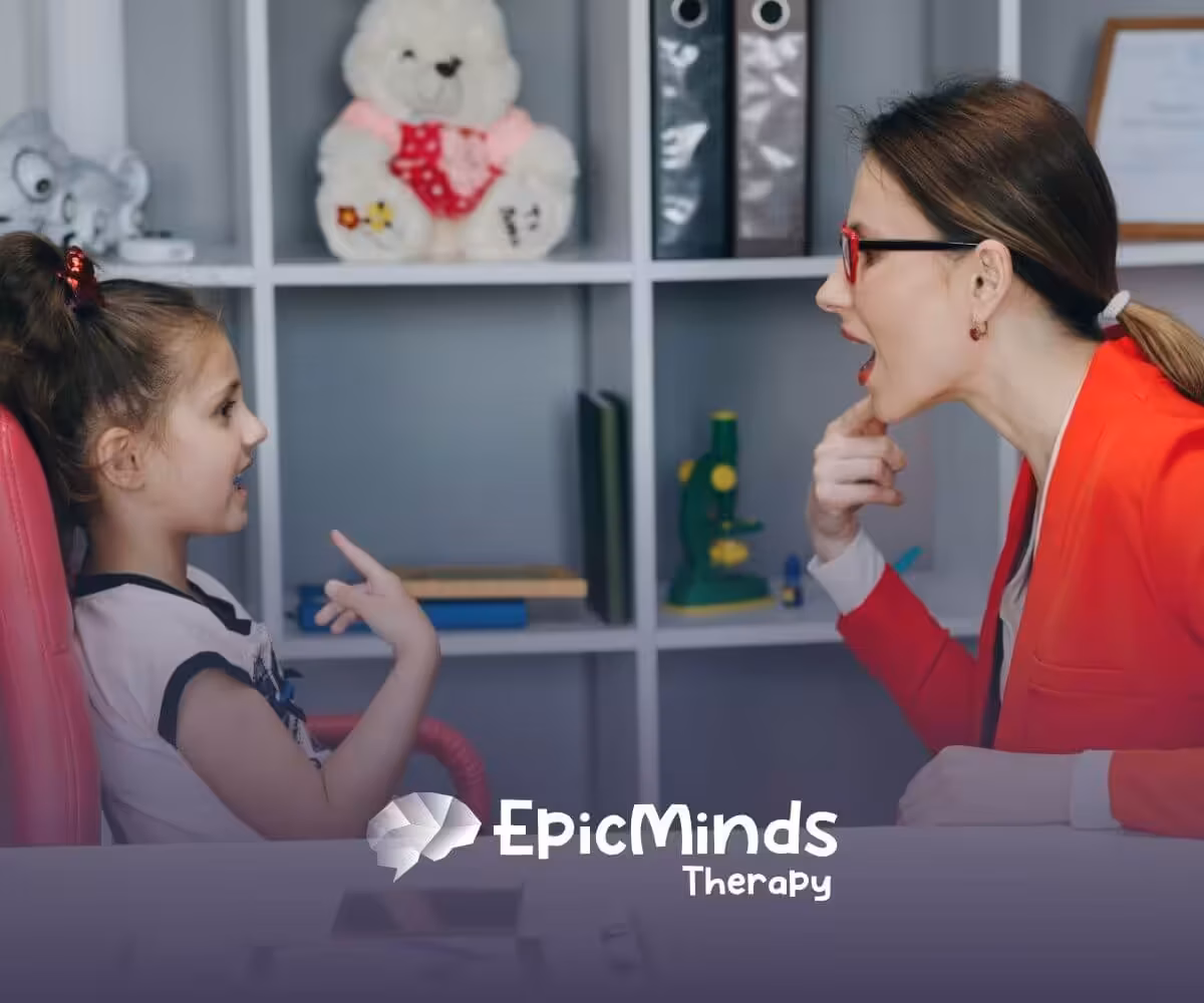 Therapist helping a young girl practice speech sounds during ABA therapy session.