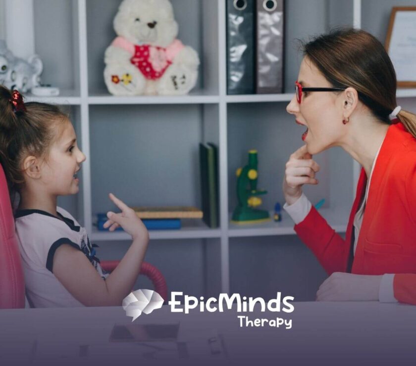 Therapist helping a young girl practice speech sounds during ABA therapy session.