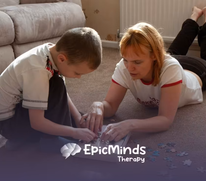An ABA therapist and an autistic child are working together on a puzzle during in-home ABA therapy in NC.