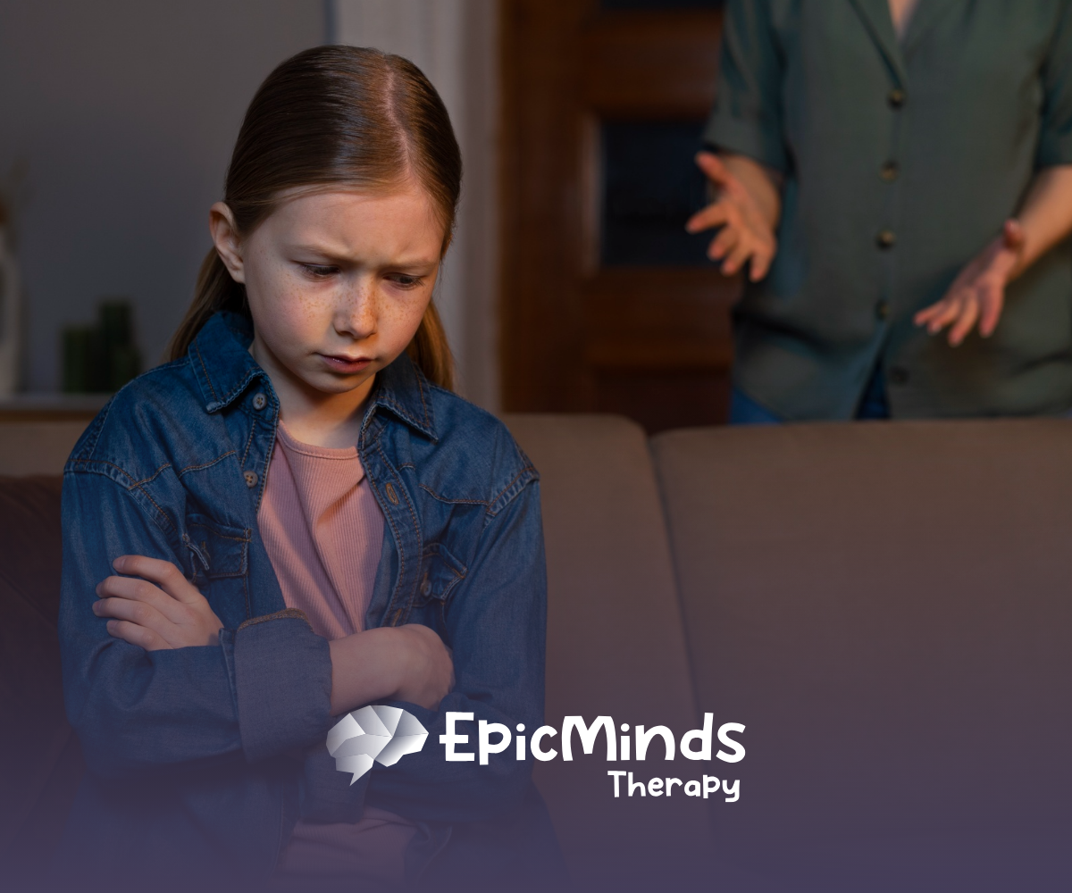 A kid with a frowning face sitting on a couch