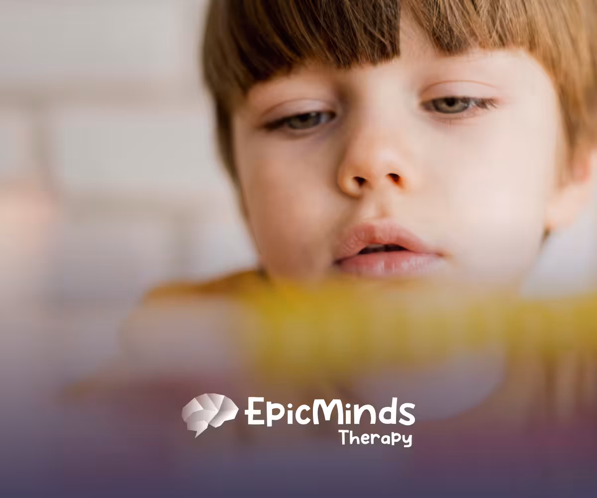 A kid with low-functioning autism looking at a toy