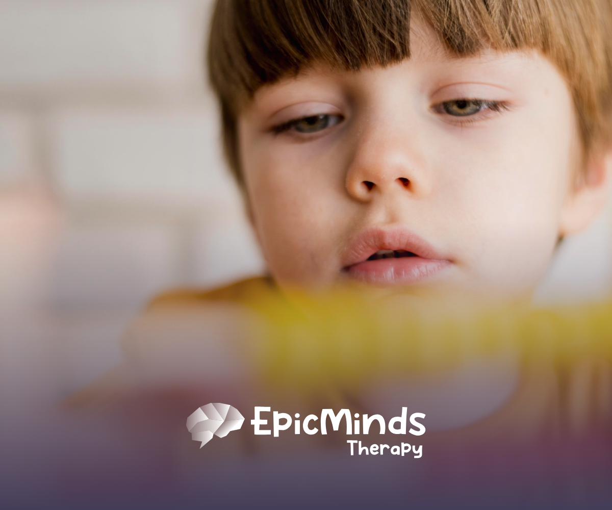 A kid with low-functioning autism looking at a toy