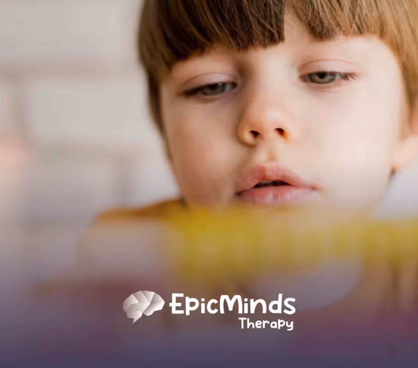 A kid with low-functioning autism looking at a toy