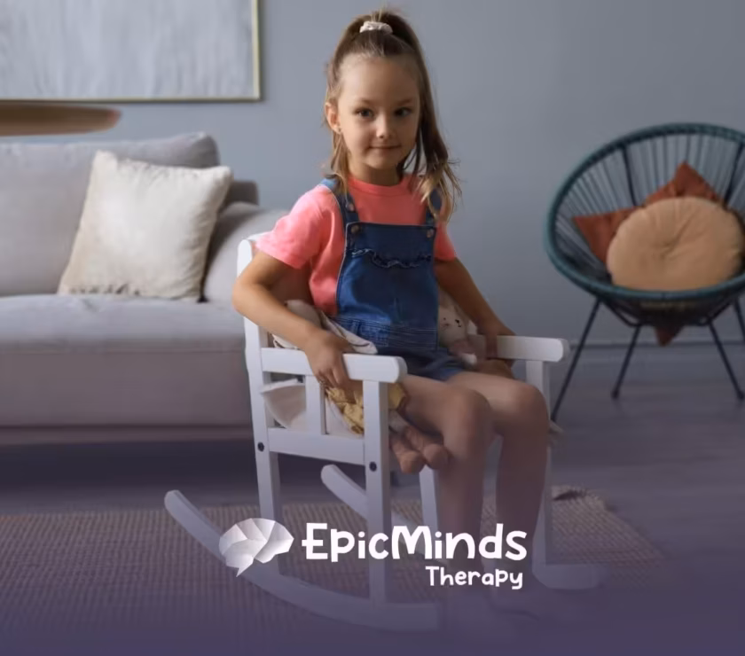 A young girl with autism sitting and rocking in a small white rocking chair indoors.