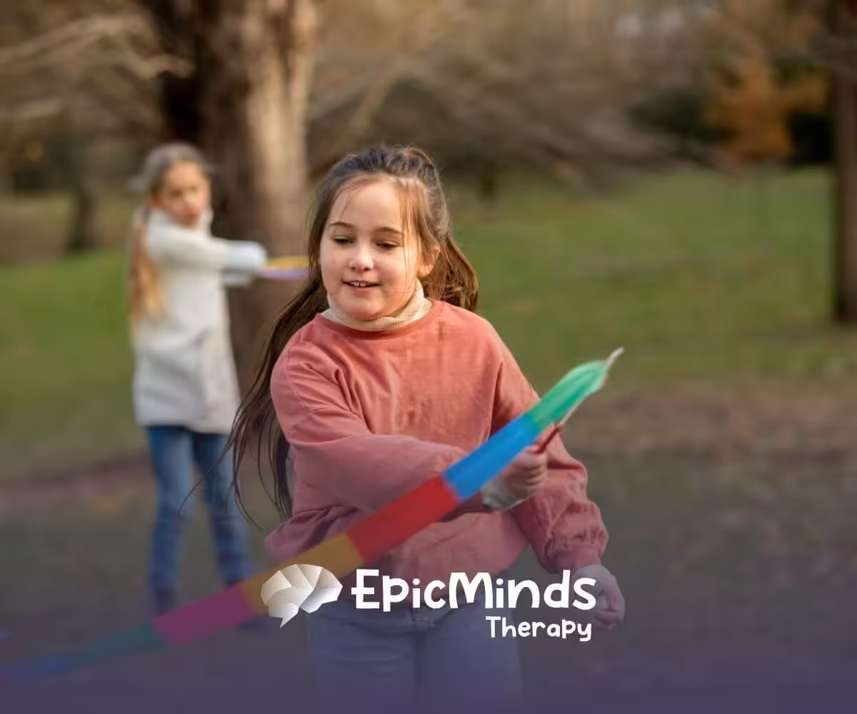 Girl with autism happily playing with a colorful ribbon outdoors in a park in NC.