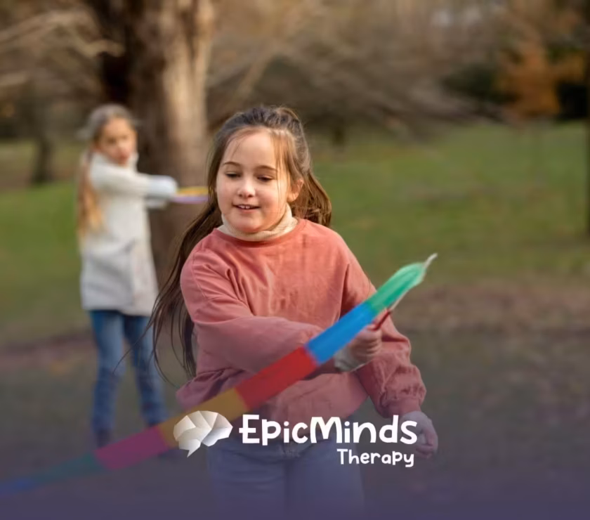 Girl with autism happily playing with a colorful ribbon outdoors in a park in NC.
