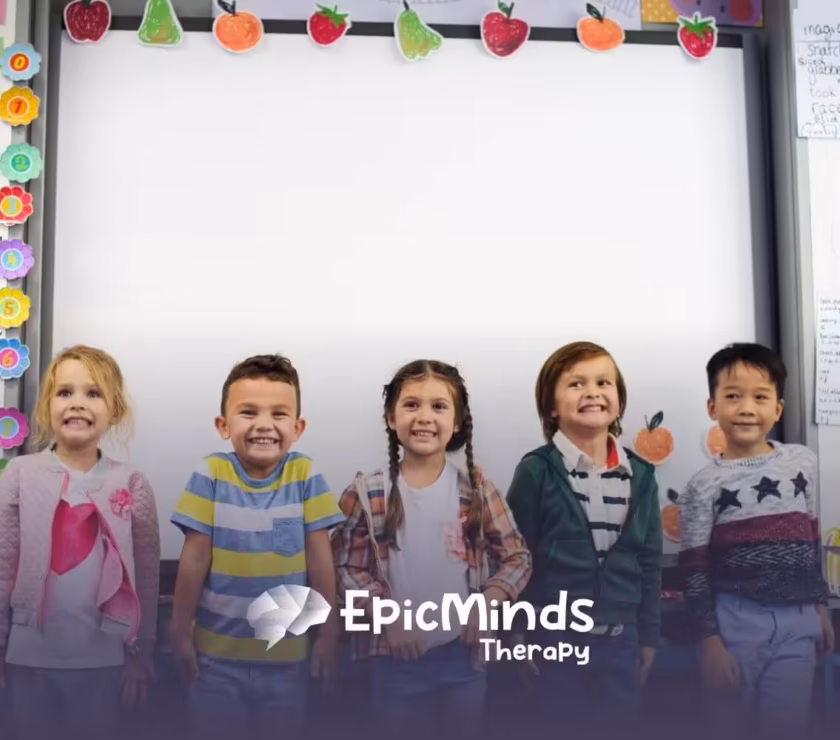 Five children with autism smiling together in a classroom.